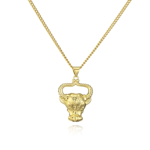 Macro shot of 18K gold plated bull head pendant with detailed engraving on Cuban chain