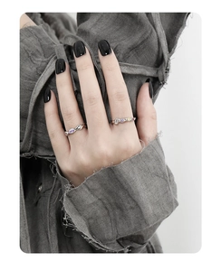 Detail shot of a s925 silver ring featuring geometric purple zircon on a model hand