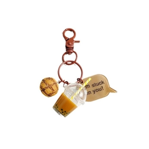 Schattige melkthee beer sleutelhanger met ananasbroodje en bedeltje op witte achtergrond