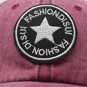 Vintage washed red cotton baseball cap with embroidered star patch and distressed finish