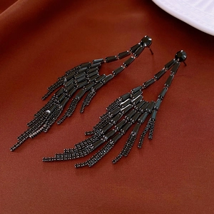 Gros plan de boucles d'oreilles à franges noires avec strass scintillants au style géométrique