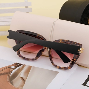 Details einer Sonnenbrille mit Schildpatt-Rahmen und lila Verlaufsgläsern auf Lederetui
