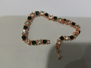 Détail du bracelet en or rose orné de zircons verts et blancs sertis avec précision