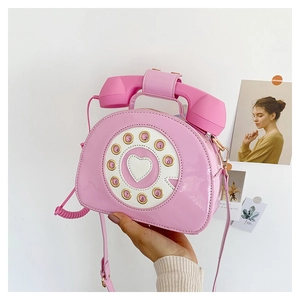 Close-up of pink retro telephone shaped handbag with creative heart dial details