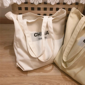 Détail de sacs cabas en toile épaisse kaki et beige avec texte imprimé China Bounce Back