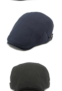 Detail view of cotton knitted newsboy caps in navy and black with side metal buckles