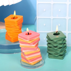 Detalle de velas geométricas en espiral naranja, rosa y verde con molde de silicona
