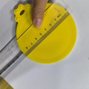 Macro shot of a yellow silicone pet food can lid being measured with a clear ruler for size