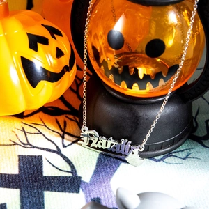 Close-up of stainless steel Harley nameplate pendant with festive pumpkin background
