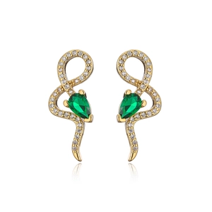Macro shot of 18K gold snake earrings with green zircon drops and pavé crystals