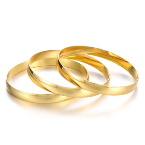 Set of three classic minimalist golden stainless steel bangles with a polished finish