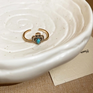 Macro shot of vintage resin open ring with turquoise stone and crown heart details