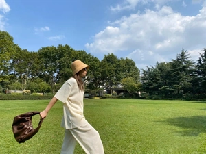Outdoor look with hand-woven raffia bucket hat and matching brown leather handbag