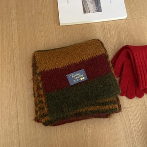 Detalle de bufanda de punto suave con rayas de colores y guantes rojos de invierno