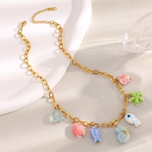 Detail of 18K gold plated necklace with colorful ceramic sea life charms like starfish