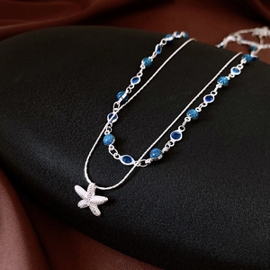 Détail du collier double rang en argent avec pendentif étoile de mer et perles