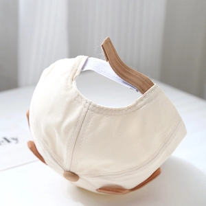 Détail de la sangle réglable et des oreilles d'animaux sur la casquette pour bébé