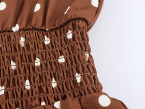Detail der gesmokten elastischen Taille am dunkelbraunen Polka-Dot-Kleid im Retrostil