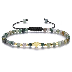 Detailed close-up of mixed stone beaded bracelet with a gold heart charm and black cord