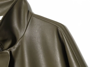Macro detail of dark olive faux leather jacket featuring stand collar and shoulder seams