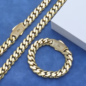 Gepolijste 14K gouden Cubaanse kettingset met iced-out S-logo op blauw fluweel