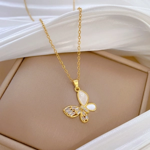 Elegant gold butterfly necklace with shell wings and zircon crystals on a velvet box
