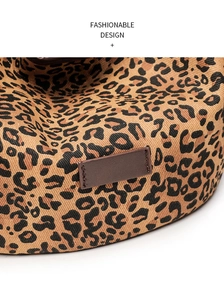 Macro detail of leopard print canvas bag with a brown leather patch and fine stitching