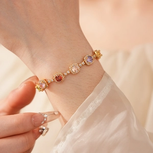 Macro detail of vintage gold bracelet featuring colorful square zircons on model wrist