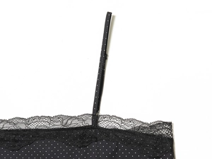 Vue macro détaillée du haut noir à pois avec bordure en dentelle délicate au décolleté