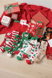Close-up of assorted festive coral fleece socks with Santa and reindeer patterns