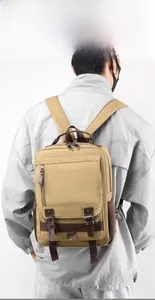 Khaki canvas backpack with leather accents shown on a model against a clean background