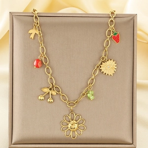 Detailed view of golden necklace with colorful resin flower and fruit charms on silk