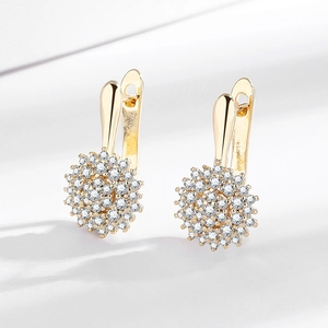 Golden sunflower huggie earrings with sparkling zircon stones in a floral design