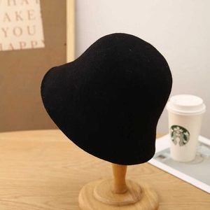 Classic black wool felt bucket hat for women on wooden stand for autumn and winter
