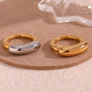 Close-up of two-tone gold and silver minimalist thick line rings on beige felt pad