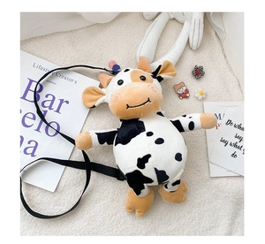 Flat lay of a cute black and white cow plush crossbody bag with cozy lifestyle props