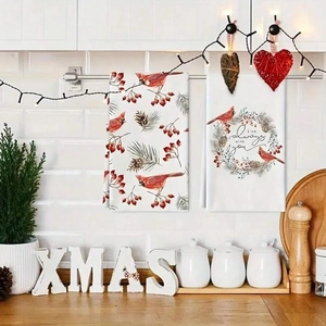 Close-up of Christmas kitchen towels featuring cardinal birds and festive pine cones