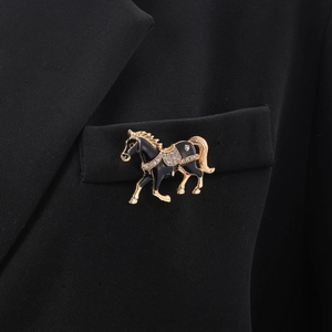 Detailansicht einer luxuriösen Pferde-Brosche mit schwarzer Emaille und Strass auf einem Anzug