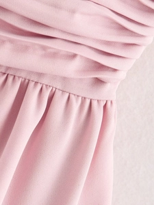 Detailed view of pink fabric with elegant draped pleats and gathered waistline texture