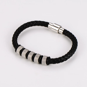 Detail of men's black braided leather bracelet with silver textured metal beads