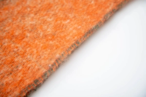 Macro shot of thick orange and grey textured wool-blend jacquard fabric with soft finish