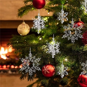Set of clear acrylic snowflake ornaments hanging on a Christmas tree branch