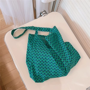 Macro detail of green and navy blue retro geometric pattern on a soft fabric tote bag