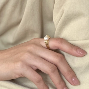 Elegant 925 sterling silver pearl ring in gold finish worn on a finger for a stylish look