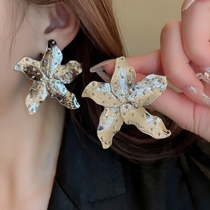 Detailed view of silver flower fan earrings featuring a unique hammered dot texture