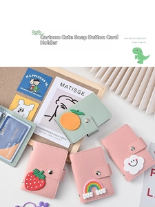 Detailed view of cartoon card holders in pink and mint green with 3D silicone fruit charms