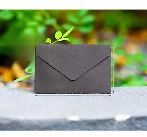 Macro view of a black 105x69mm mini specialty paper envelope on a stone surface