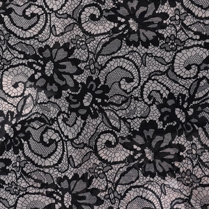Macro detail of black floral lace fabric with pink mesh backing and rose patterns