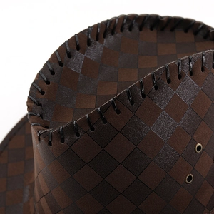 Detail of dark brown checkered cowboy hat featuring hand-stitched brim and metal eyelets