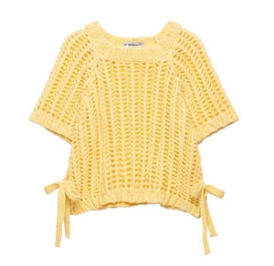 Detail of light yellow chunky knit top featuring side bow ties and openwork texture